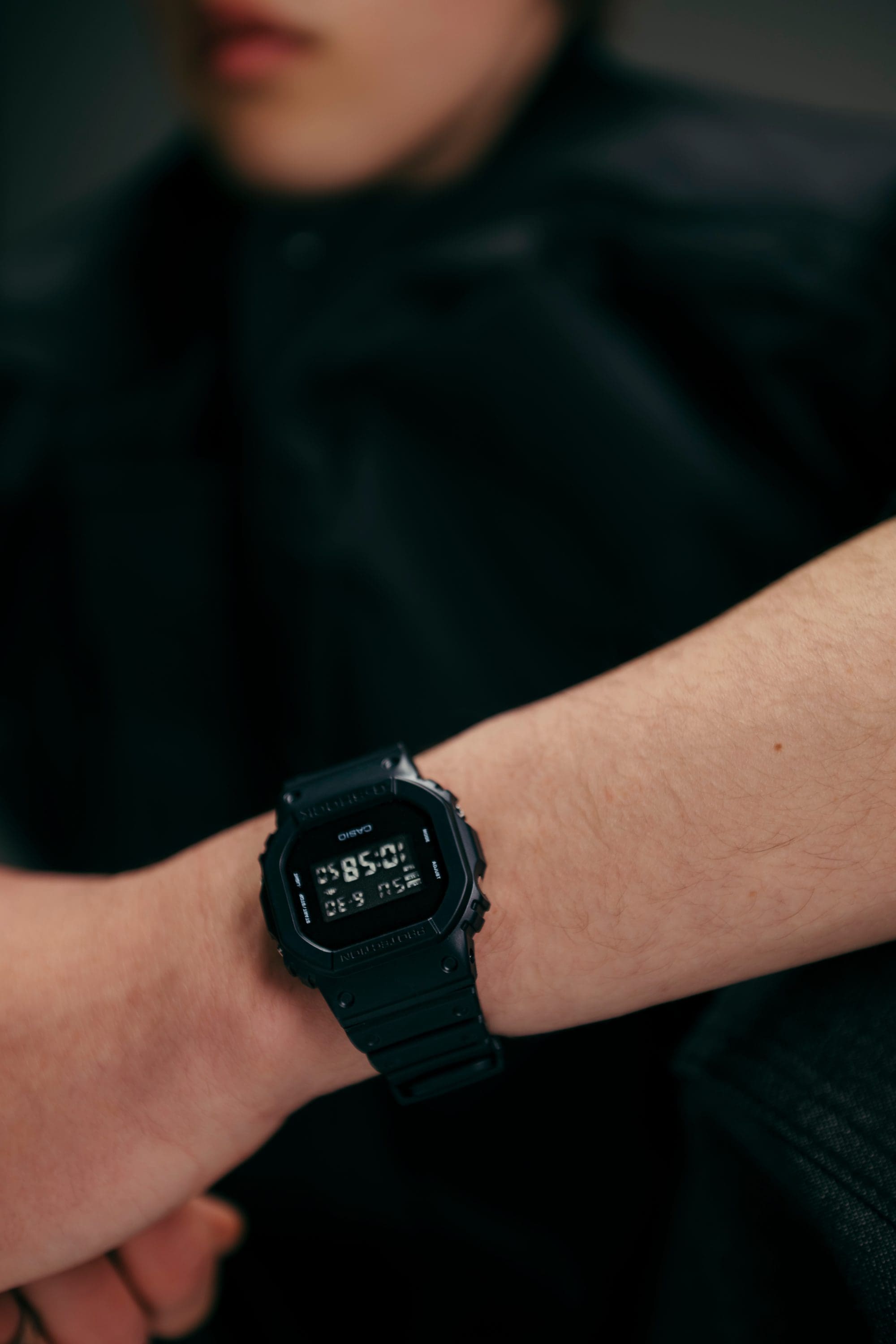 Minimal siyah stile sahip G‑SHOCK DW‑5600UB'nin bilekteki yakın plan çekimi.