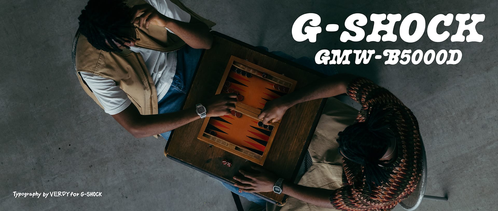 G‑SHOCK GM‑5600D takan bir kişinin evde kutu oyunu oynarken üstten görünümü.