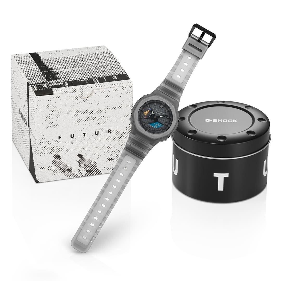 GA-2100FT-8A gray analog digital watch with grid, Casio, and FUTUR logo, next to product packaging
