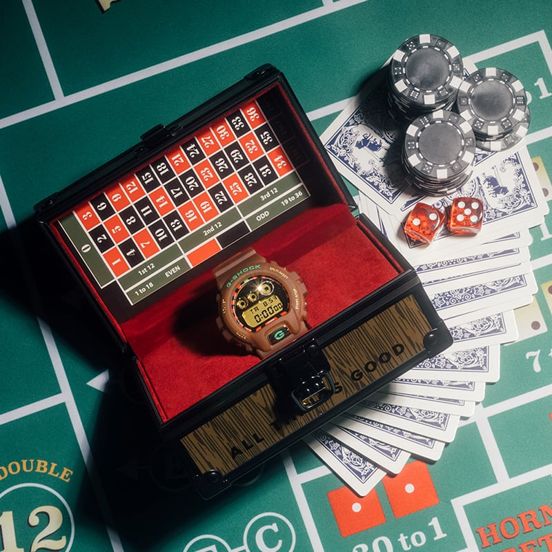 FEATURE x G-SHOCK DW6900FTR23B5 collaboration watch in its roulette table themed package on top of a roulette table