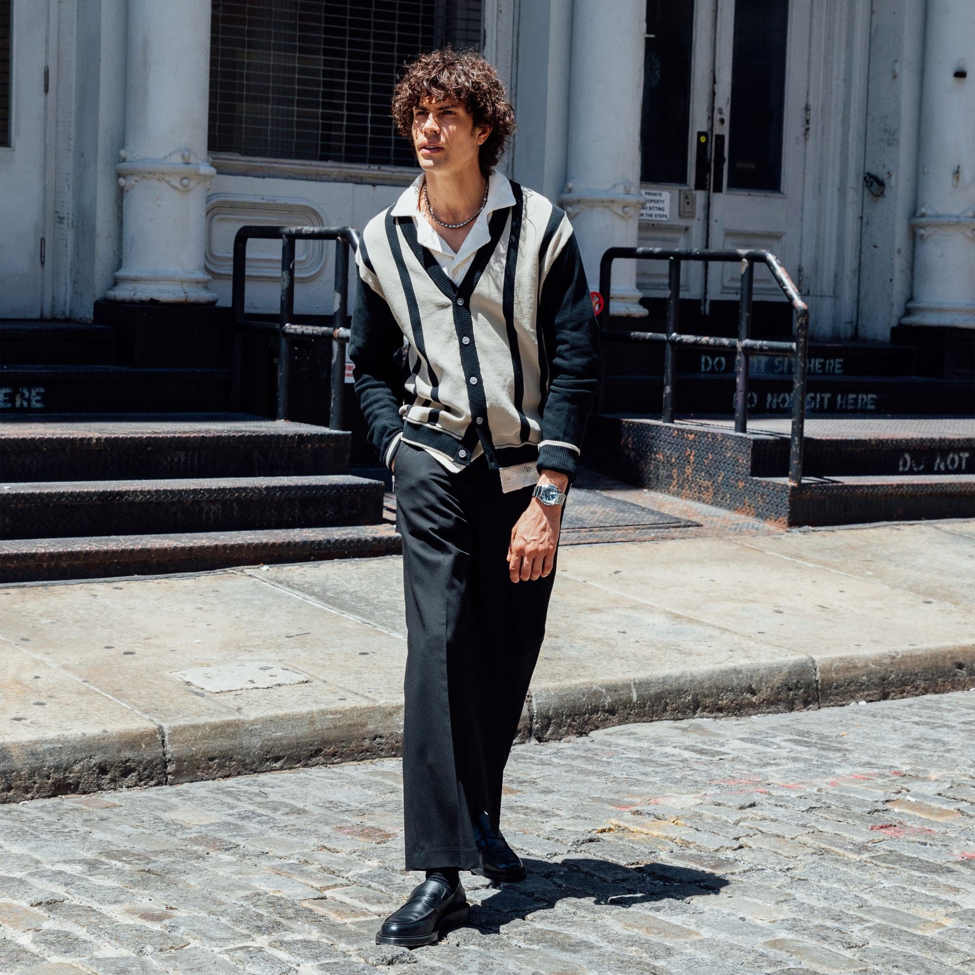 A man standing in the street wearing business casual attire sporting a G-SHOCK GM2110D-2A watch