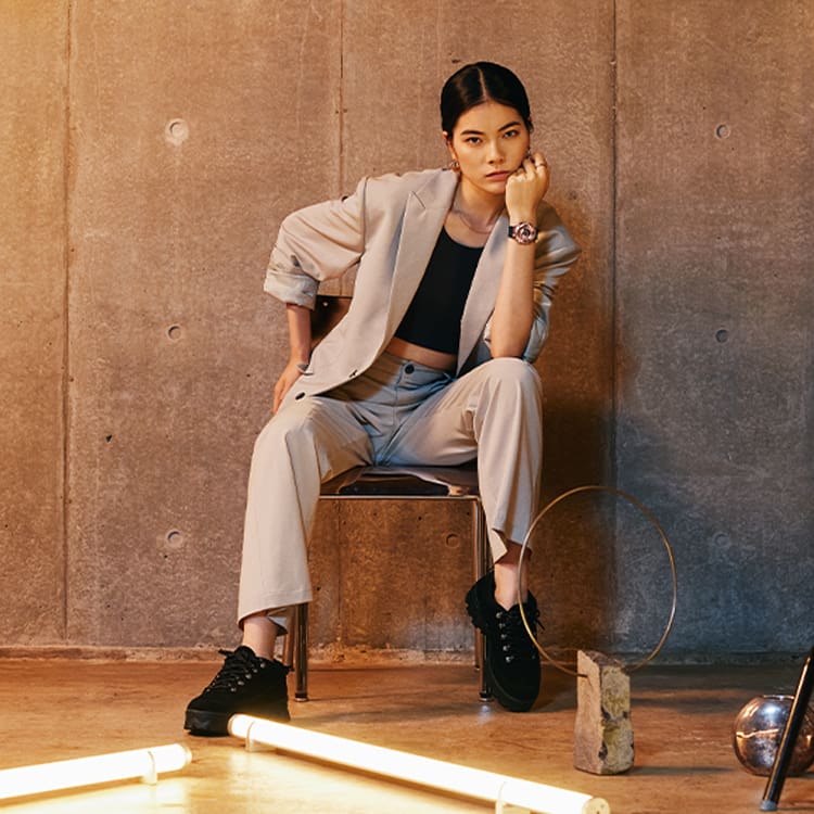 Woman sitting on a bench wearing a gms110 metal covered analog digital watch