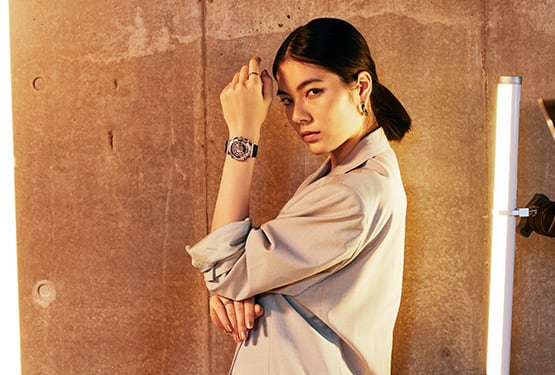 Woman with hand up near face displaying G-SHOCK GMS110 metal covered analog digital watch