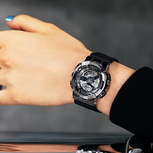 G-SHOCK GMS110 Gray colored metal covered analog digital watch on woman's wrist