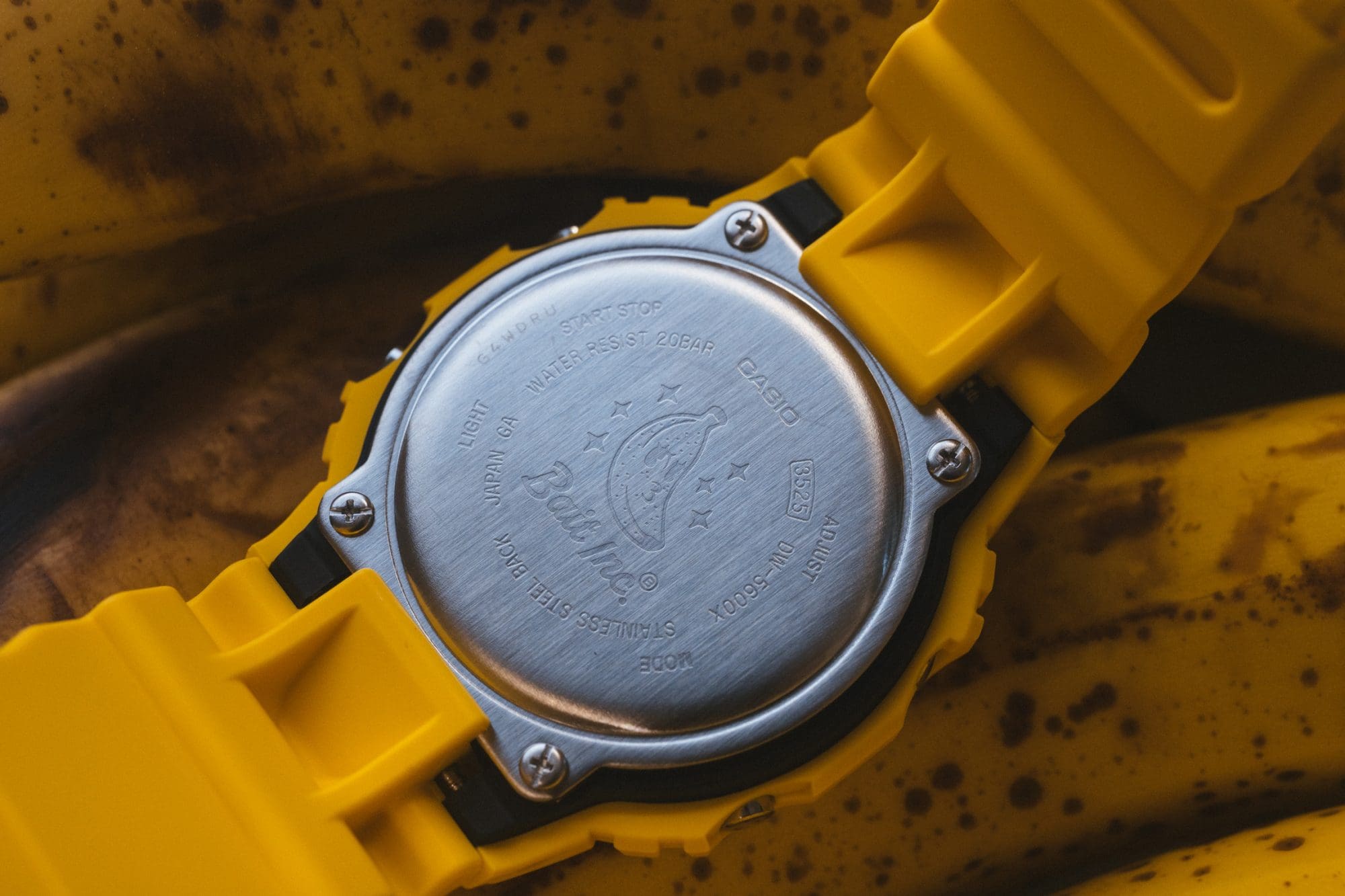 Man leaning on a care wearing G-SHOCK x TOYO TIRES DW5600TT25-1 