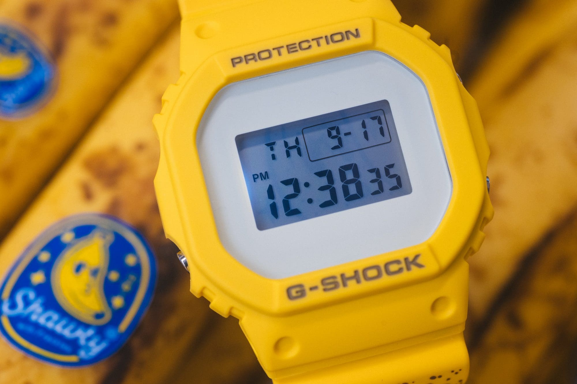 G-SHOCK x TOYO TIRES DW5600TT25-1 laid on special tin packaing beside the Proxes Sport R tire that inspired the watch design