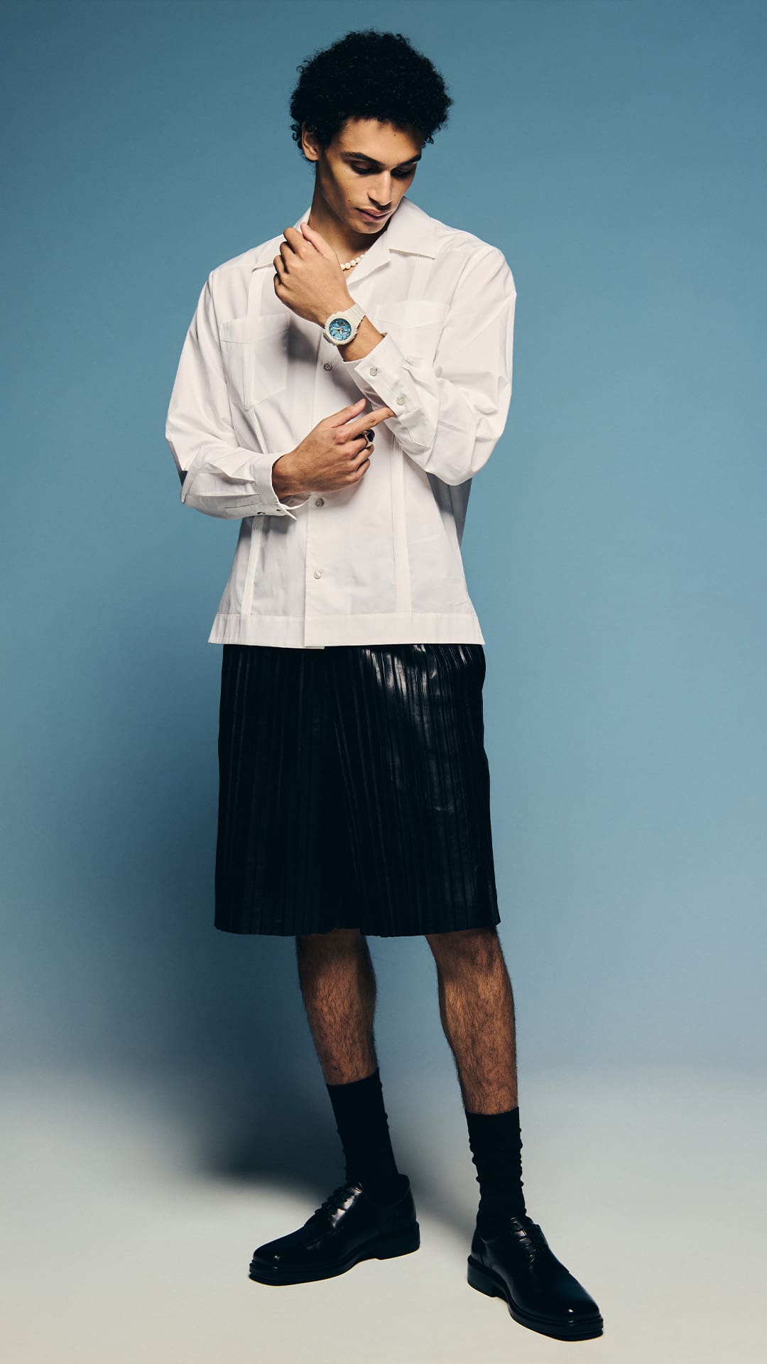 A man in a white shirt wearing the G-SHOCK GA2100AS-5A blue-dial watch denoting style