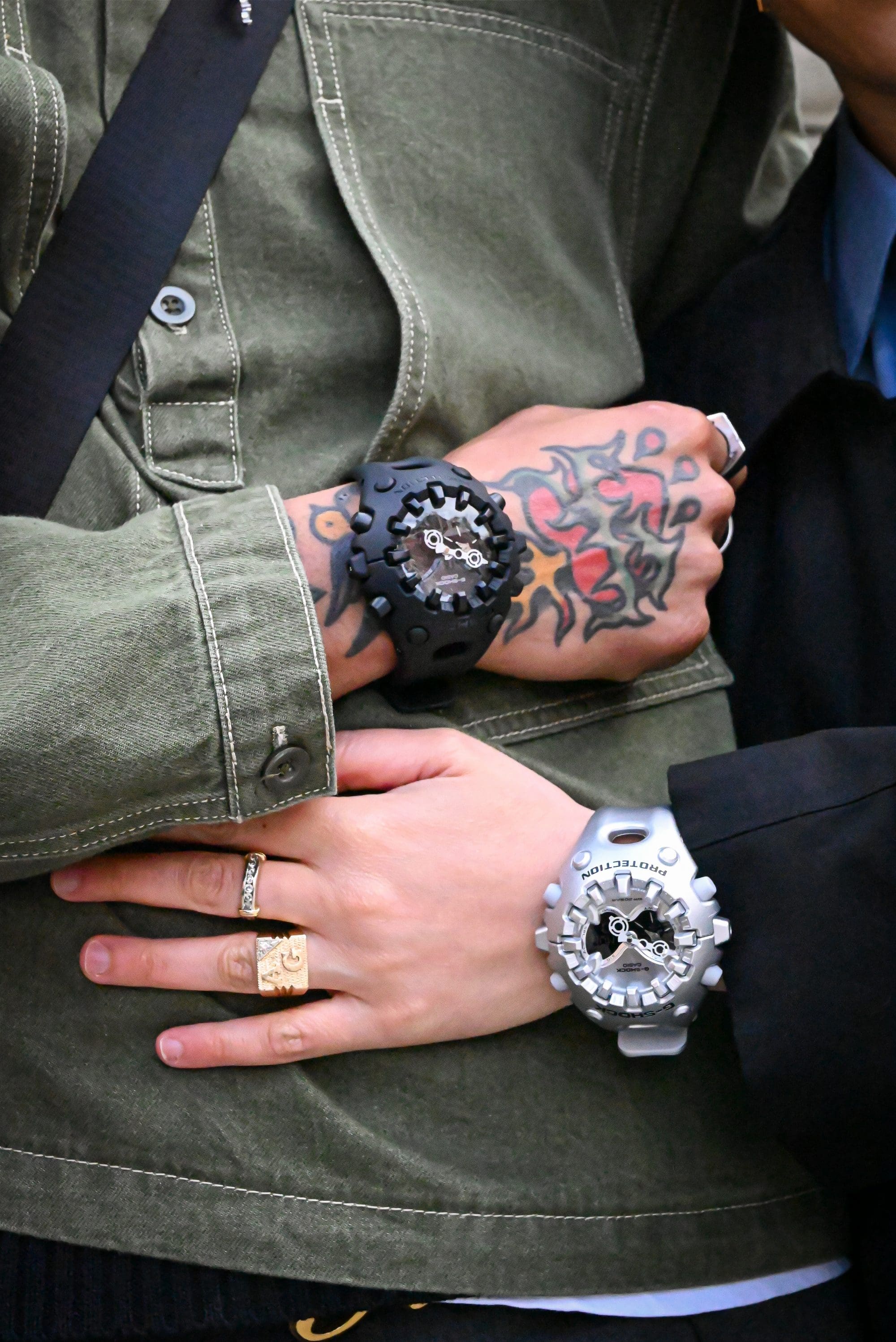 G-SHOCK GAV01-1A black watch and GAV01A-8A silver watch on people’s wrists denoting style