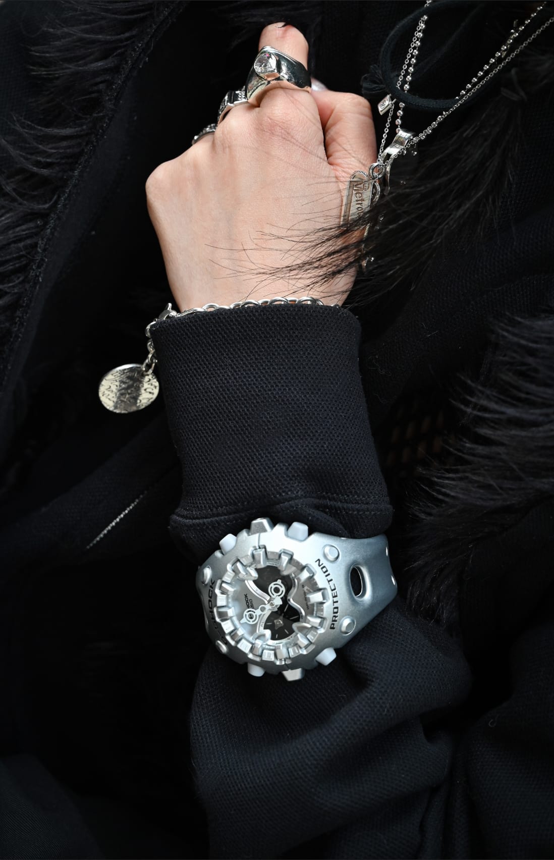 Silver G-SHOCK GAV01A-8A on a person’s wrist and contrasting against a black sleeve to denote style