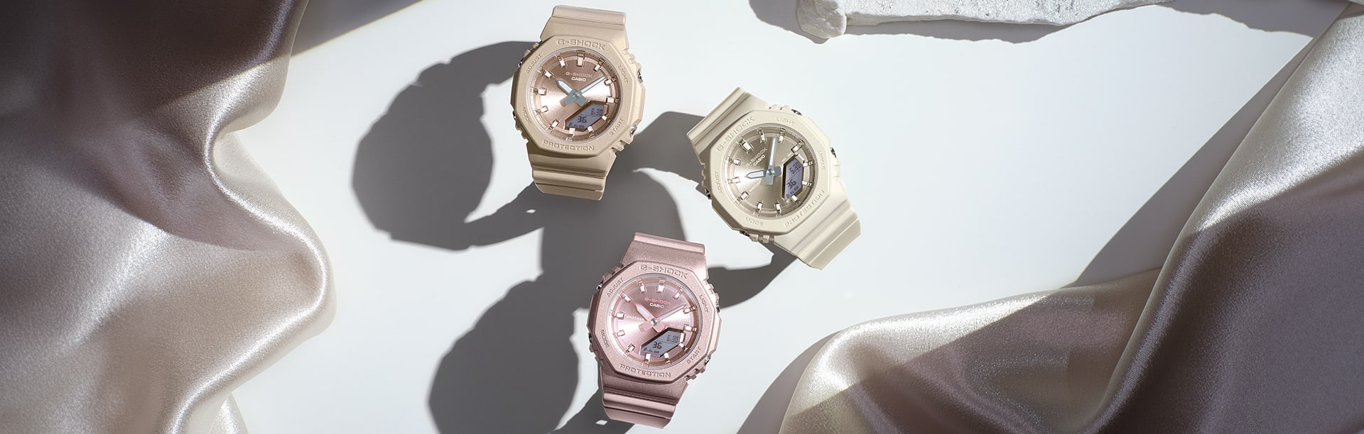 Three watches on a table with stylistic  lighting. From left: GMA- P2100ST-9A, GMA- P2100ST-4A, GMA- P2100ST-7A.