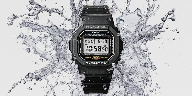 G-SHOCK DW5600E in a splash of water denoting 20-bar water resistance.
