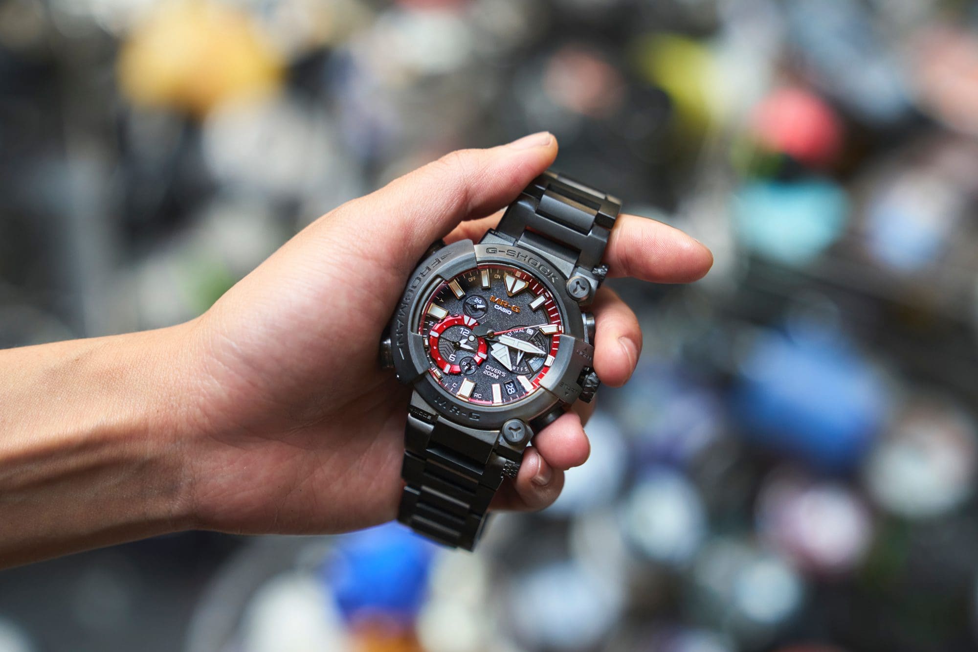 The man is holding a black watch.