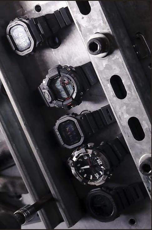 Five G-SHOCK mil-spec watch models secured on a metal test fixture.