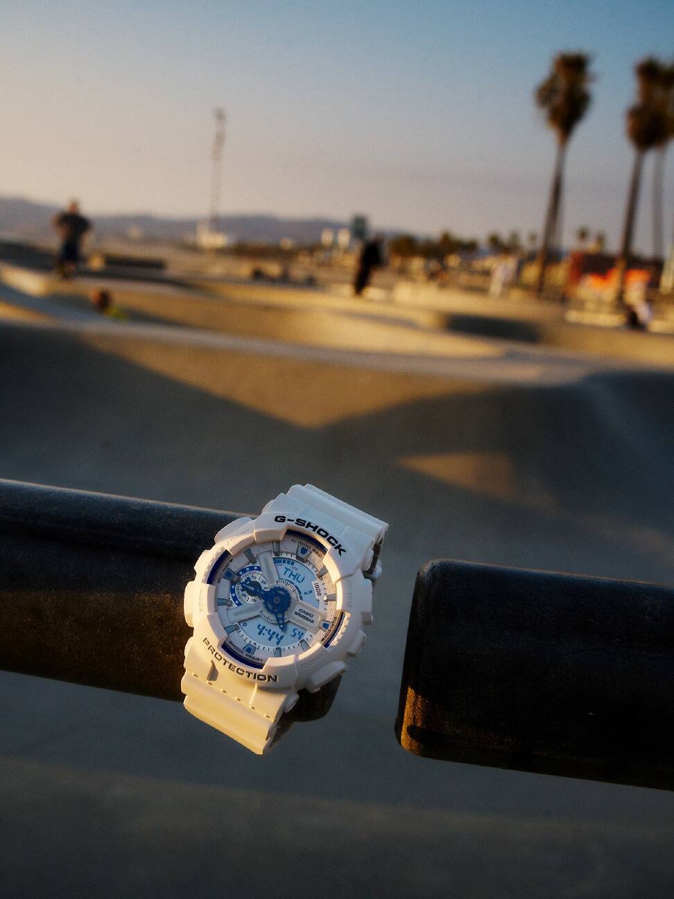 ساعة G-SHOCK باللون الأبيض على درابزين في حديقة التزلج.