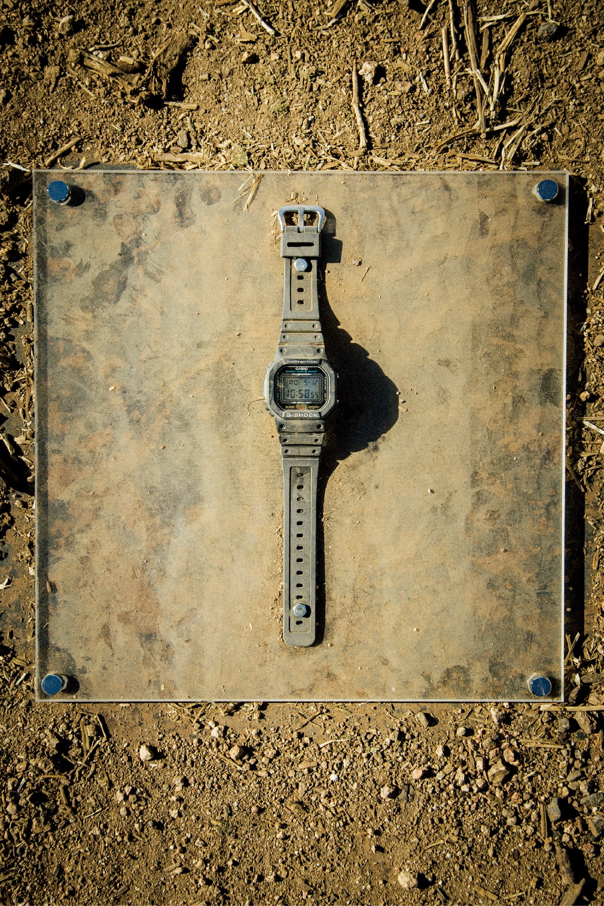 صورة لساعة G-SHOCK سوداء اللون مغطاة بالغبار بعد دهسها بشاحنة نصف مقطورة.