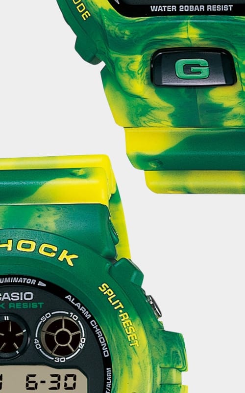 Ausschnitt des grün-gelbem Gehäuses der Casio G-Shock DW-6900MC-3 Armbanduhr und Nahaufnahme ihres grün-gelben Armbands