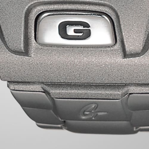 Nahaufnahme auf das G auf dem Gehäuse der Casio G-Shock DW-6900RR-8 beim Übergang zum Edelstahlarmband
