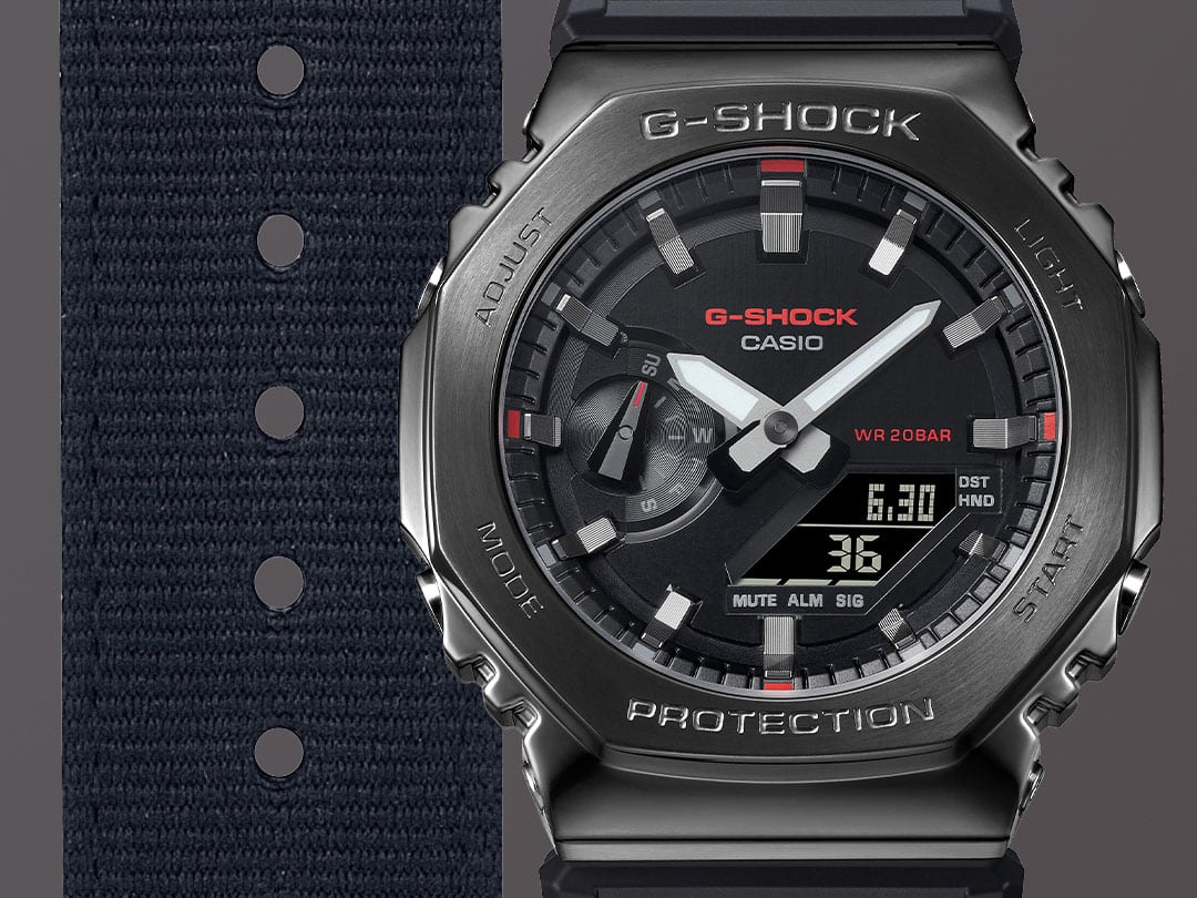 Großaufnahme auf das schwarze Stoffarmband, das schwarze Zifferblatt und das schwarze Edelstahlgehäuse der Casio G-Shock GM-2100CB-1A Hybridarmbanduhr