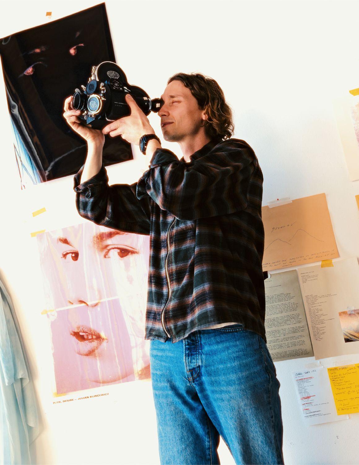Julian Klincewicz in einem Atelier beim Blick durch eine alte Filmkamera