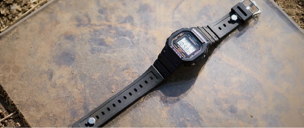 Die schwarze G-Shock Digitaluhr DW-5600 liegt auf dem Boden.