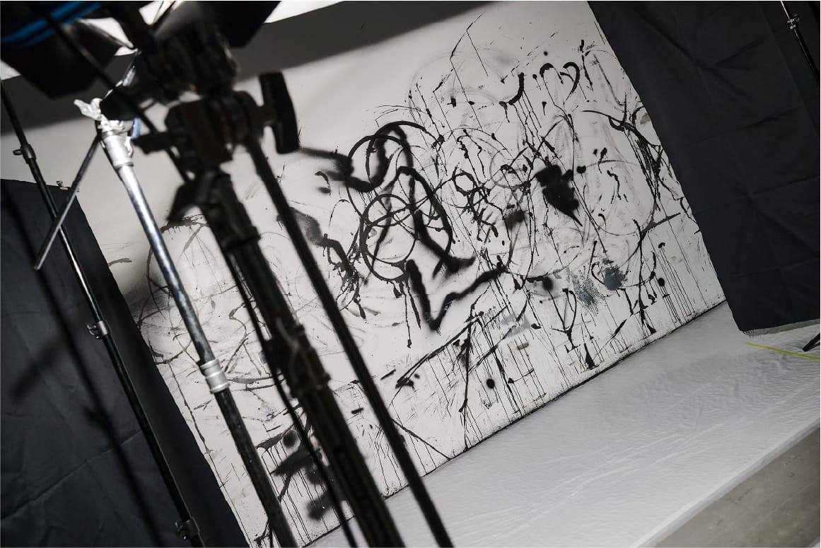 Eine weiße Wand in einem Atelier mit schwarzen Grafittis besprüht