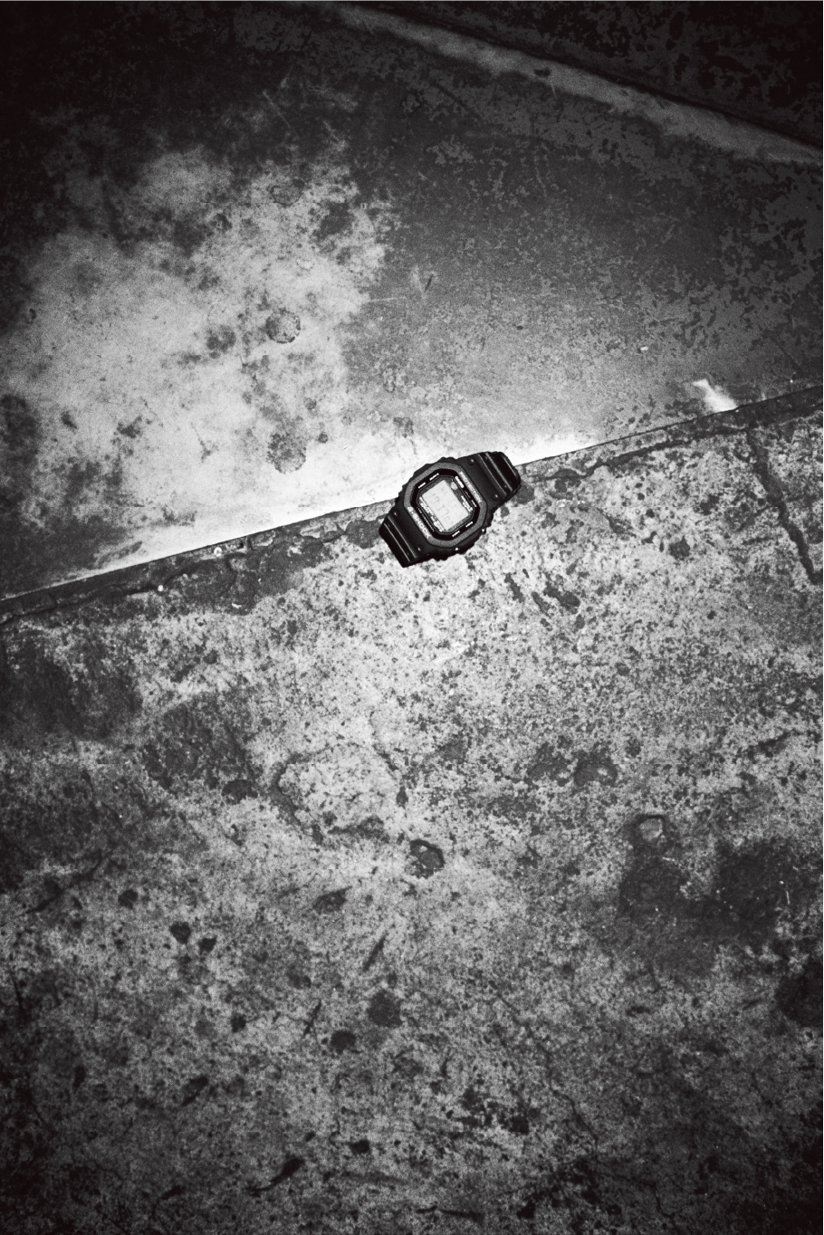 Schwarz-Weiß-Fotografie von Yusuke Yamatani von einer G-SHOCK-Uhr auf Beton.