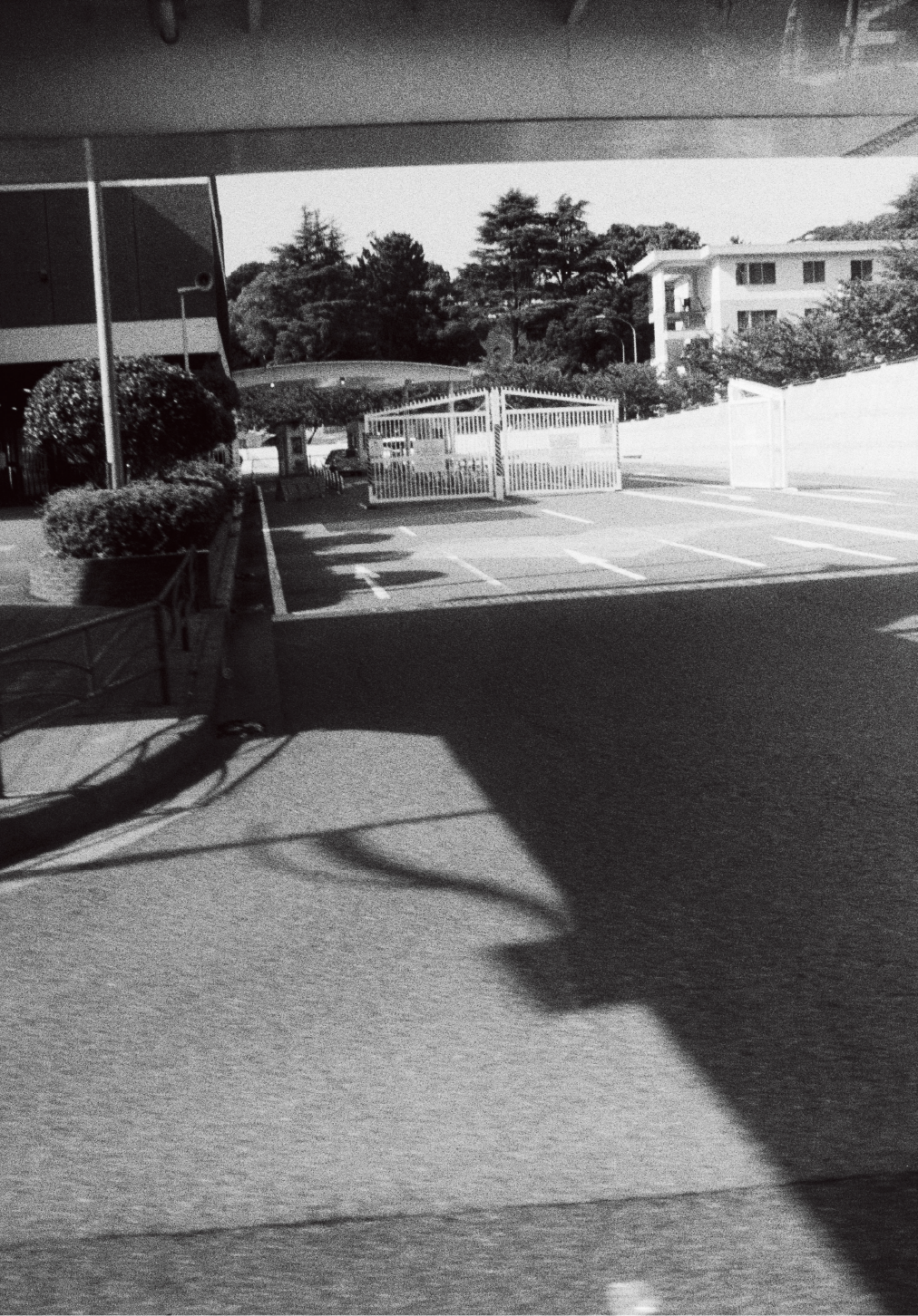 Schwarz-Weiß-Foto von Yusuke Yamatani von einem weißen Tor unter einer Brücke.
