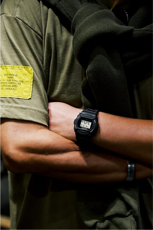 Close-up auf Obanas verschränkte Arme und seine schwarze G-SHOCK am Handgelenk.