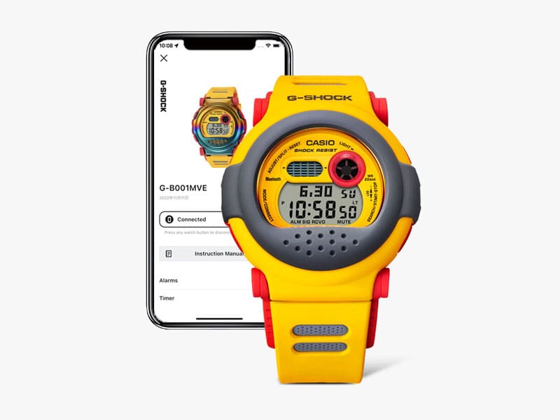 Vorne: Die digitale Casio G-Shock G-B001MVE-9 Armbanduhr, hinten: ein Smartphone mit der Casio Watches App