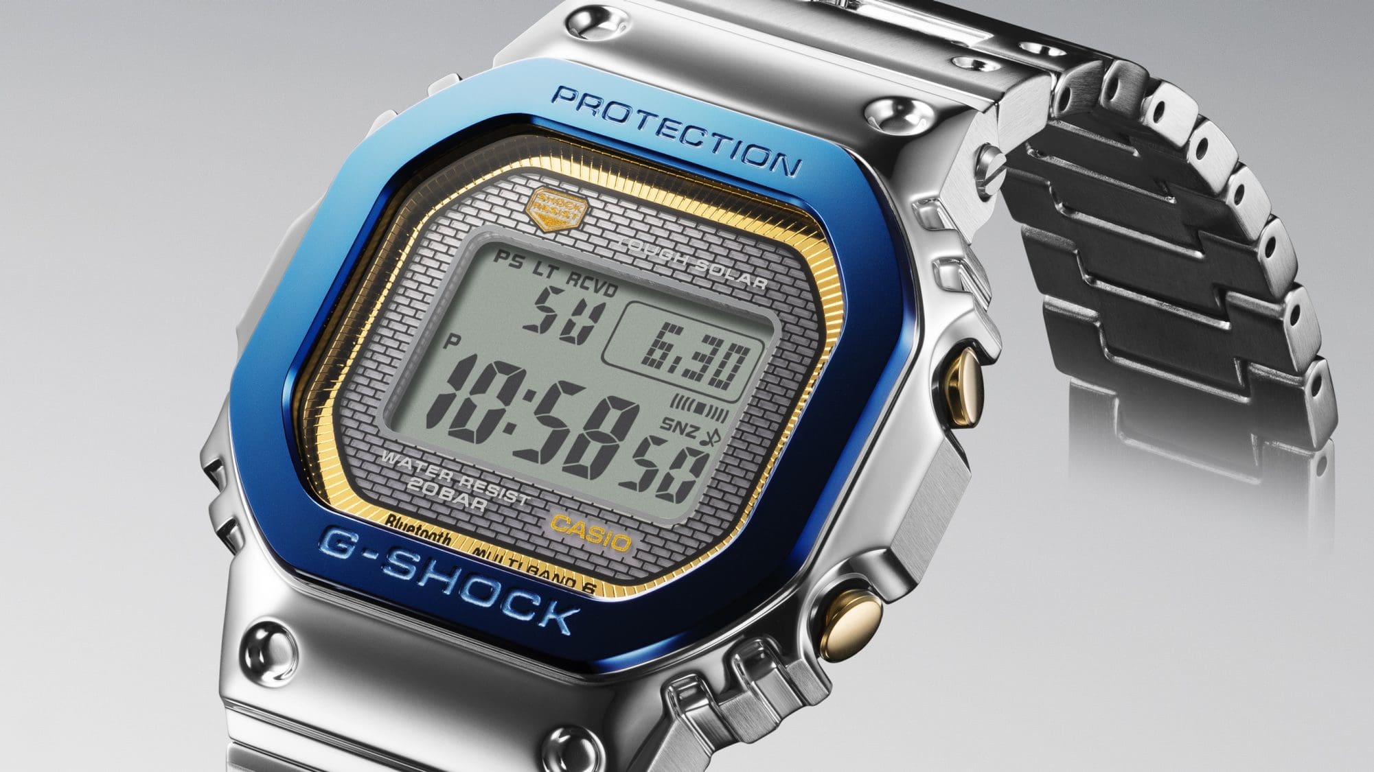 GMW-B5000SS-2 Blick von schräg oben auf Display und Gehäuse der Casio G-Shock GMW-B5000SS-2 mit silbernem Edelstahlarmband, blauer Lünette und goldenem Zifferblattrand