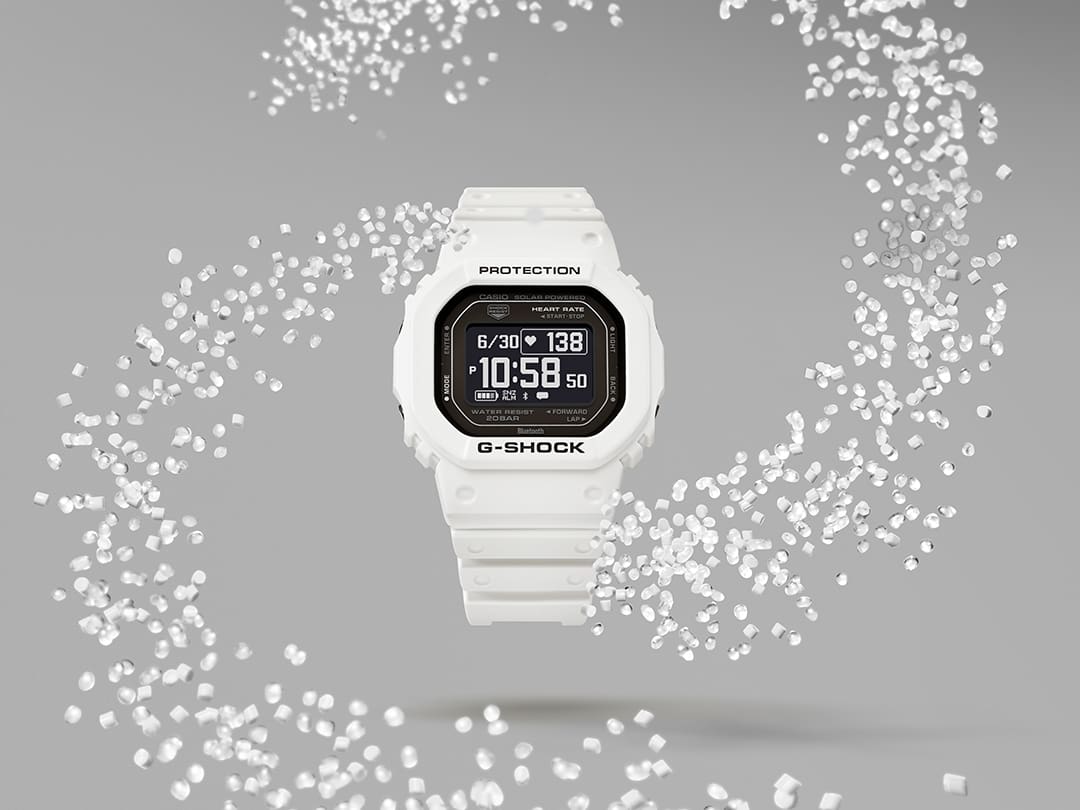 Die weiße Casio G-Shock DW-H5600-7 Sportuhr umgeben von durchsichtigen Resin-Granulat-Wirbeln