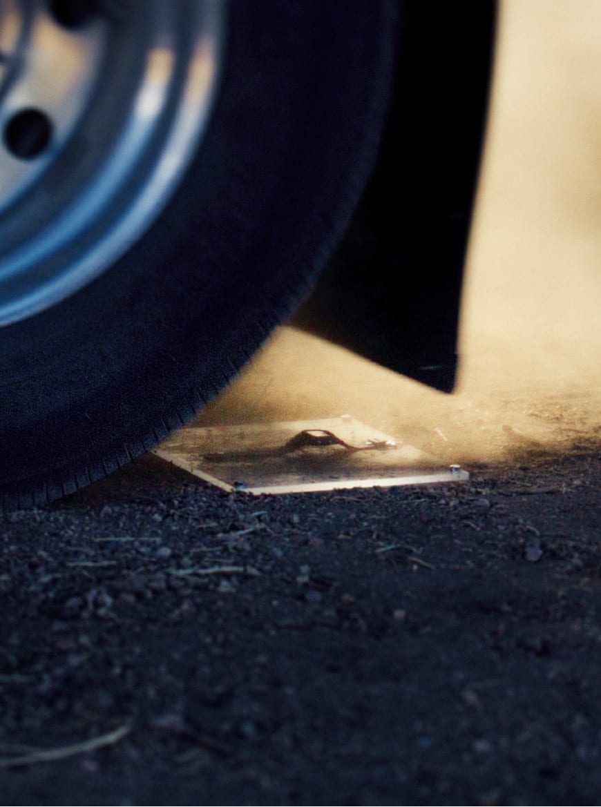 A G-SHOCK watch fixed on the ground and run over by a large tire.