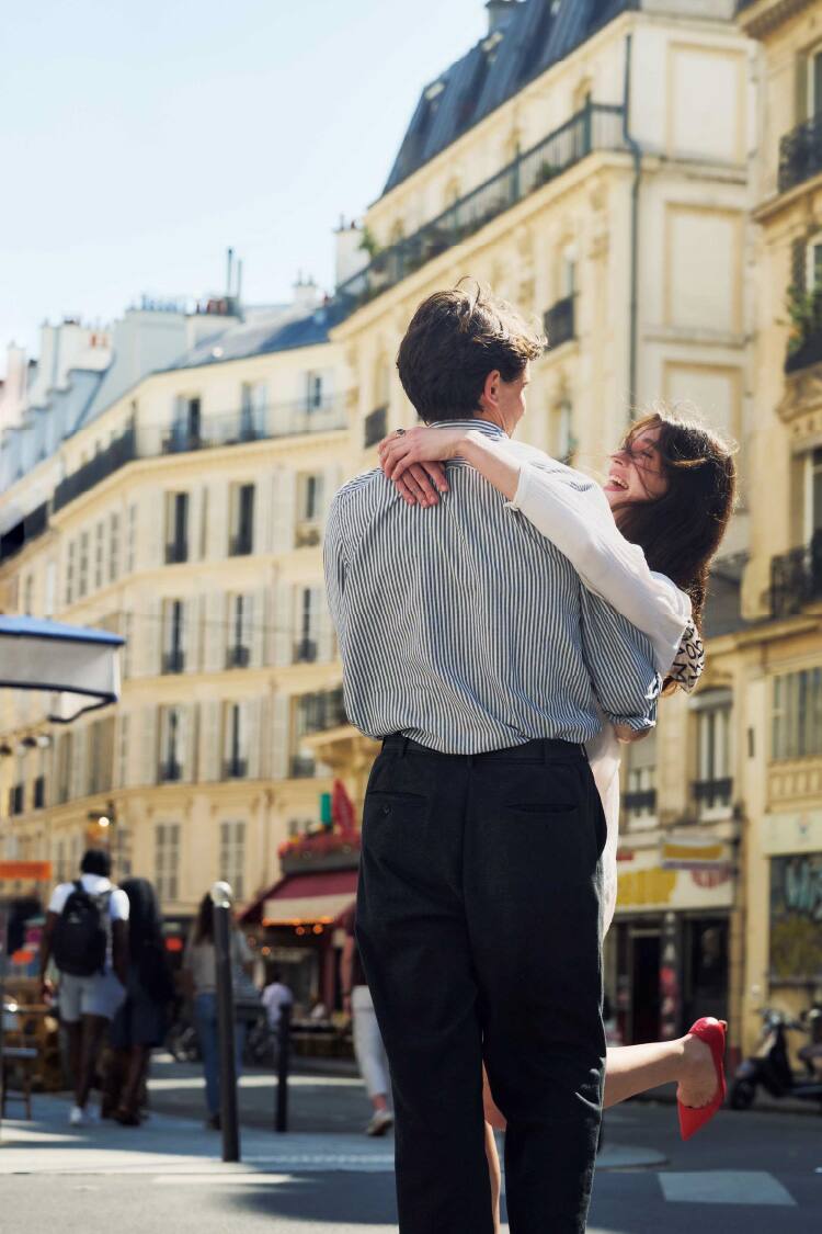 A couple embraces on a Parisian street.