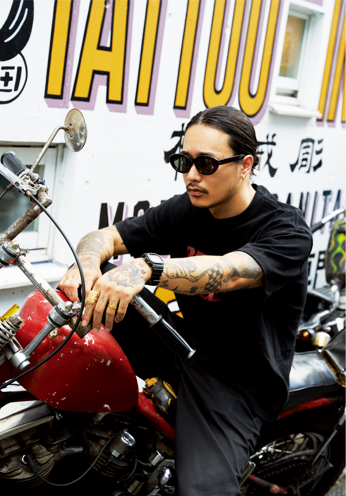 Len Yamada posing on a motorbik while wearing his G-SHOCK and sunglasses.