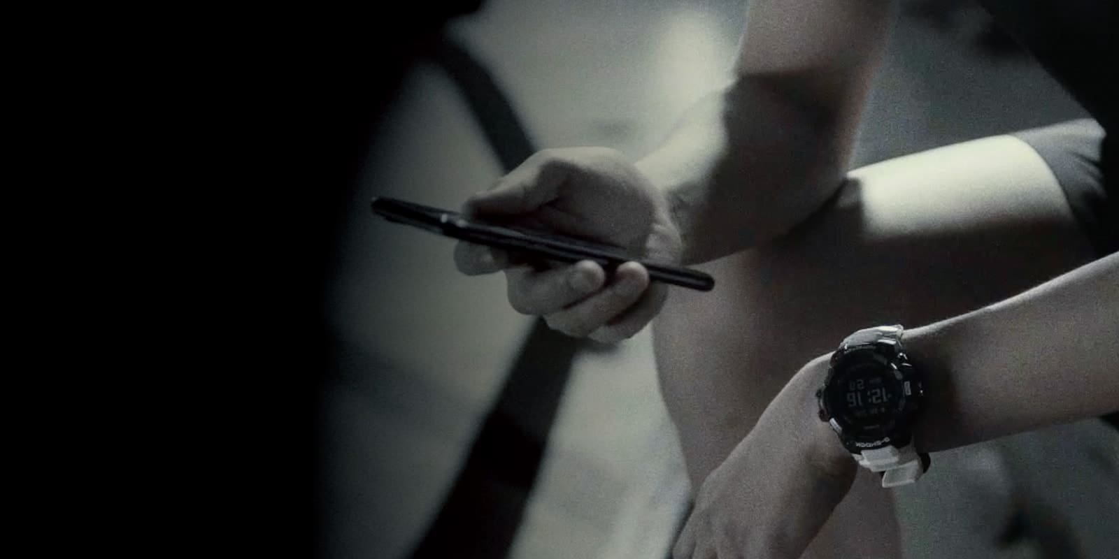 A blurred view of someone looking at their smartphone while wearing a Casio G-Squad GBD-H1000 sports watch on their wrist