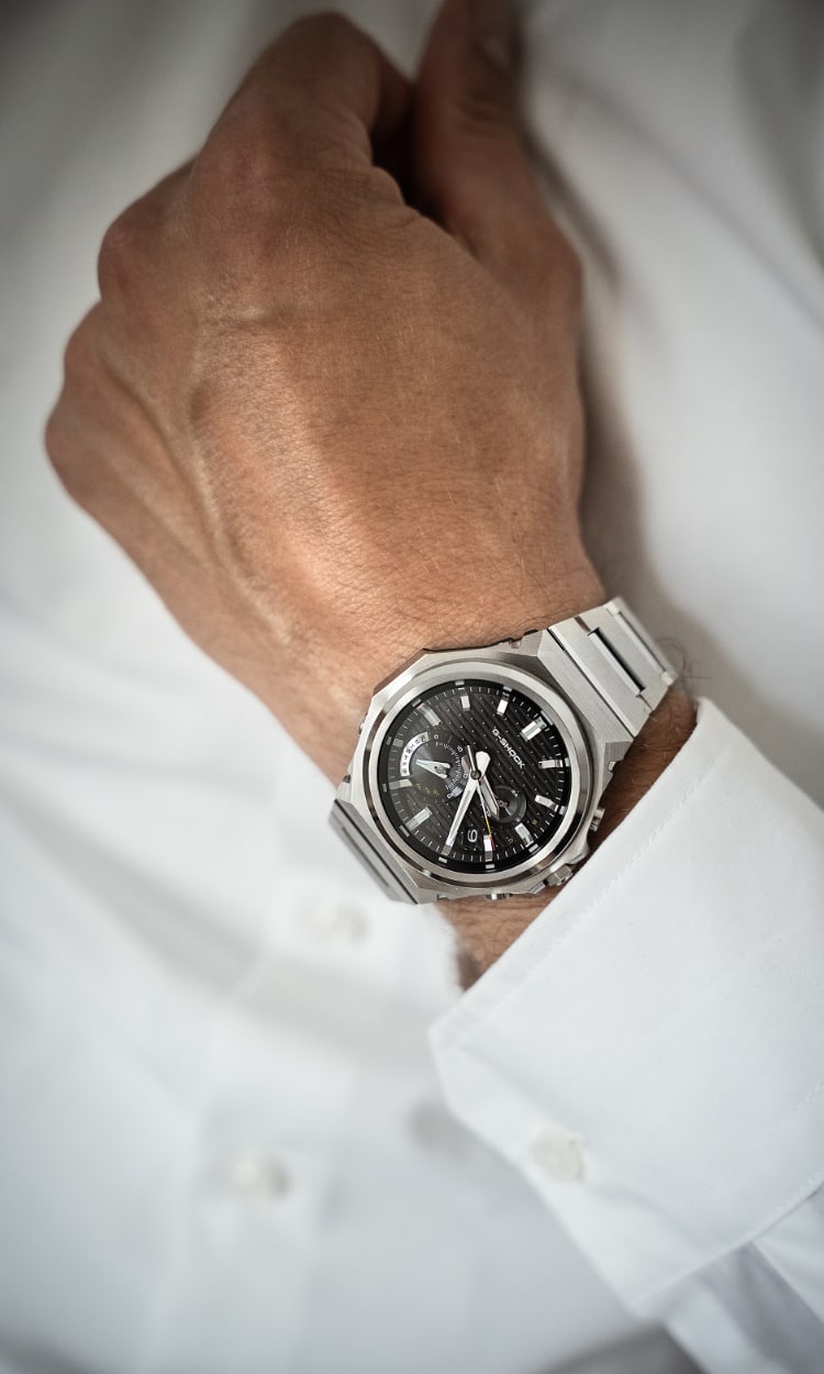 Close-up of a man wearing a white shirt and a GST-B1000 wristwatch with a black analogue dial