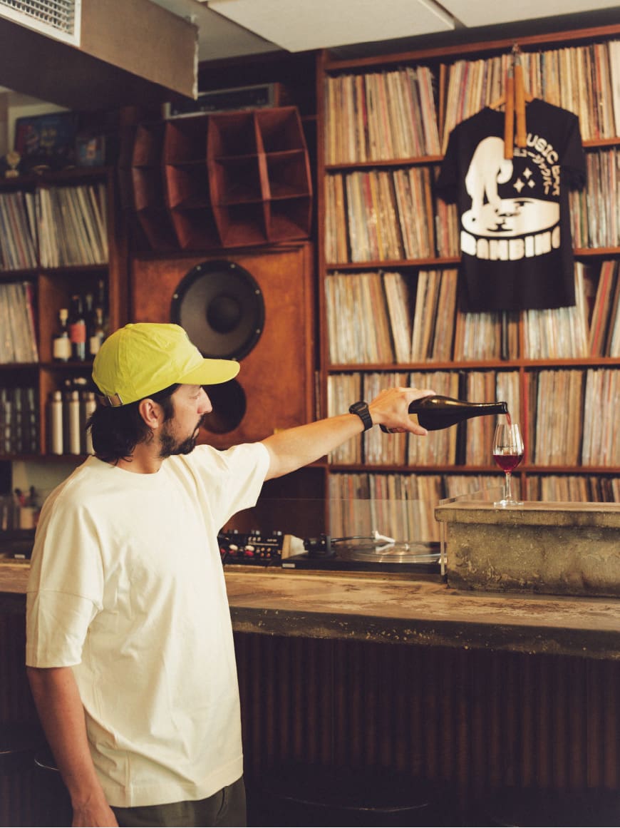 This is a photo of a staff member selecting records inside Bambino, a Paris café known for its curated music and coffee culture.