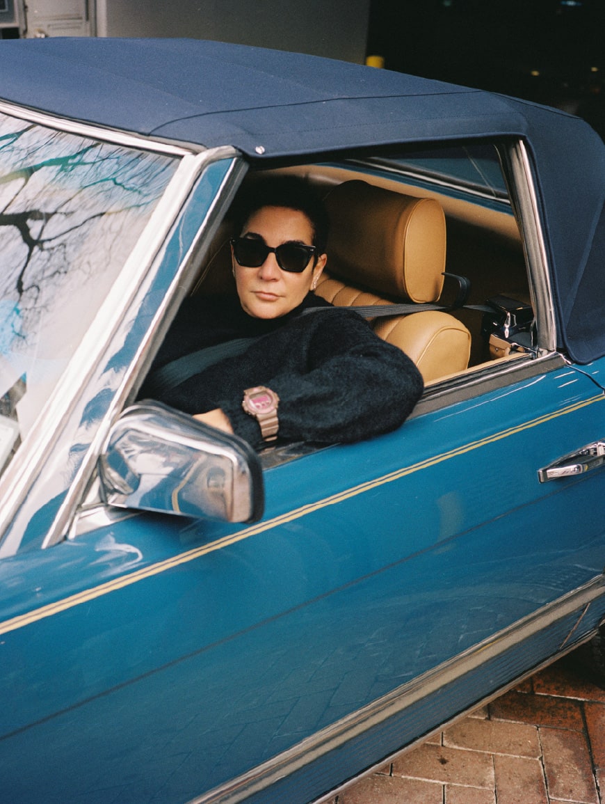 Retrato de la diseñadora gráfica Ruba Abu-Nimah dentro de un auto clásico de Nueva York.