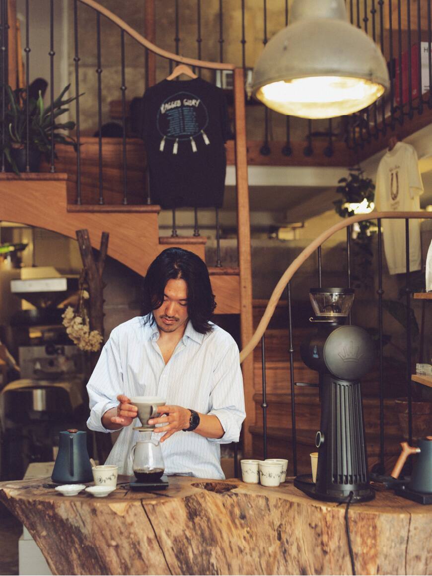 Esta es una foto de un barista preparando café en Dreamin Man, una cafetería especializada en París.