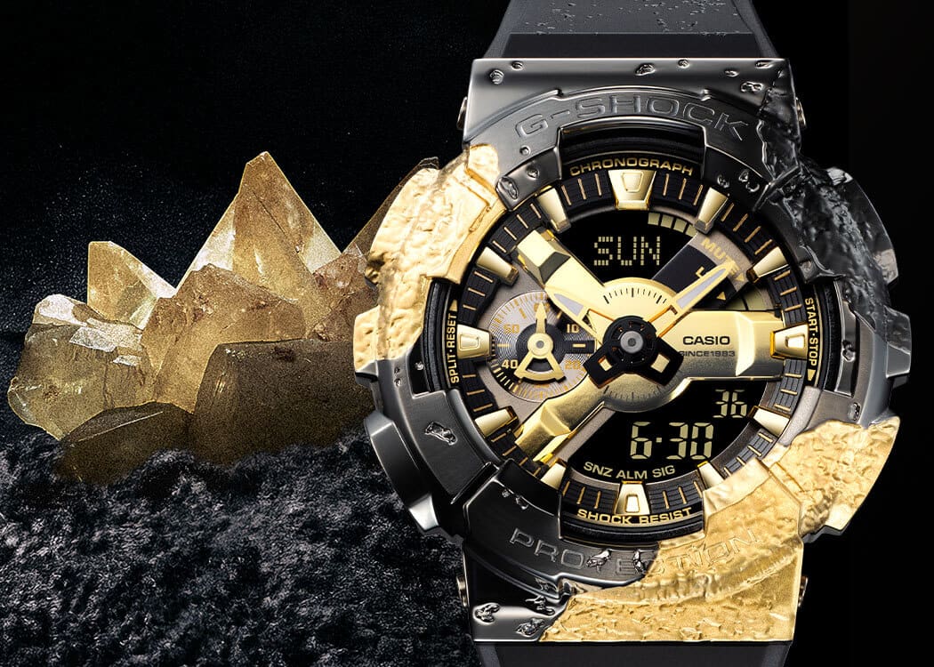GM-114GEM-1A9 El reloj conmemorativo GM-114GEM-1A9 junto a cristales dorados y roca calcita