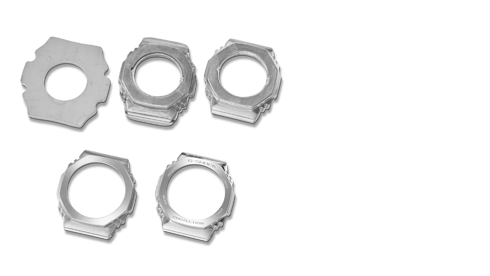 Cinco biseles plateados en diferentes estados de fabricación, desde el bruto hasta el bisel acabado