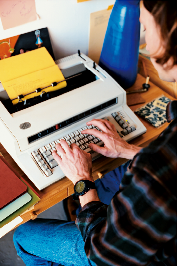 Julian sentado en su escritorio con una máquina de escribir.