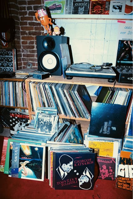 Una colección de discos y un tocadiscos en un estante de madera