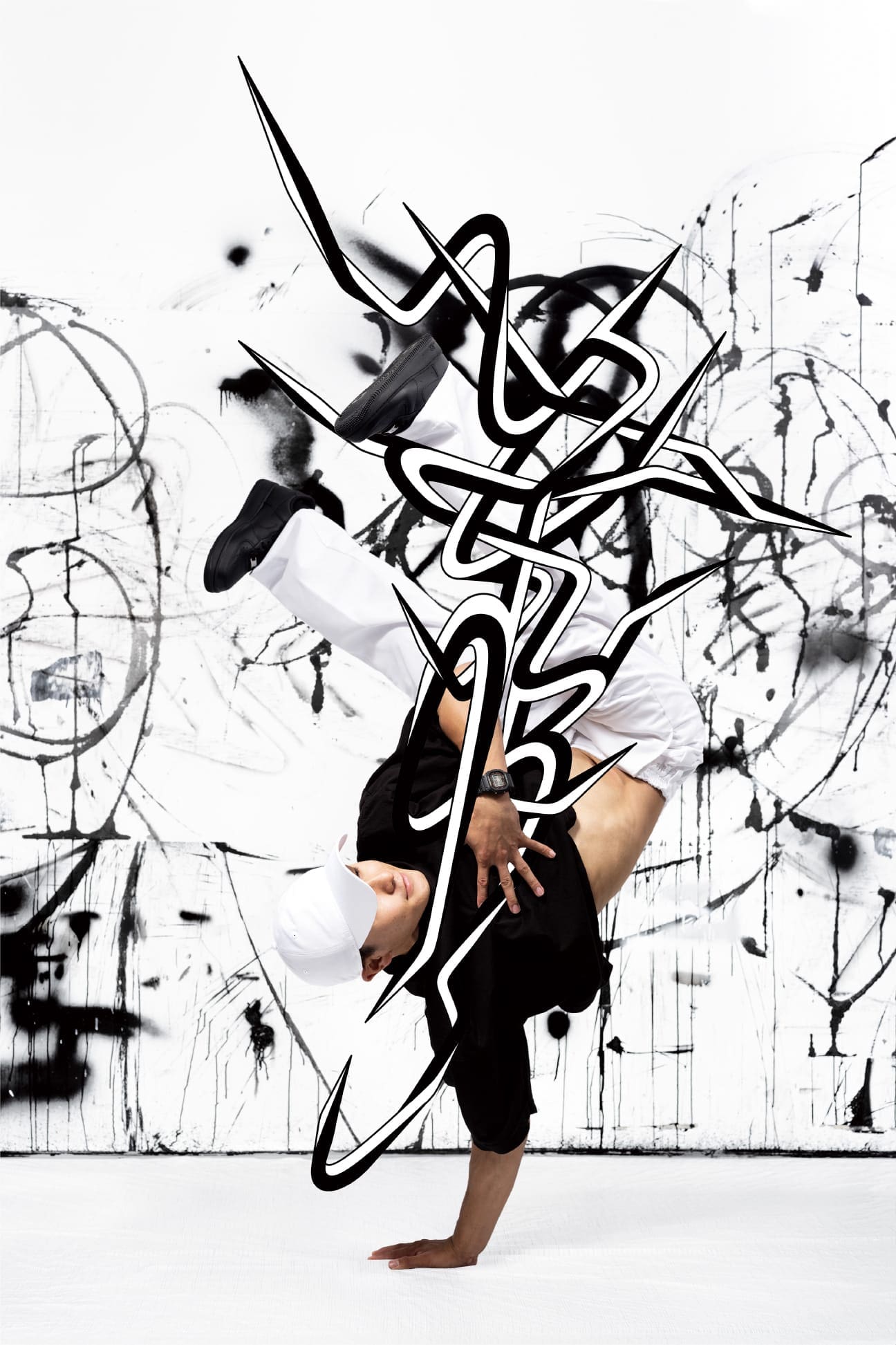 Bailarín de break dance con camiseta negra y pantalones cortos blancos en una posición de parada de manos frente a un mural de arte callejero en blanco y negro.