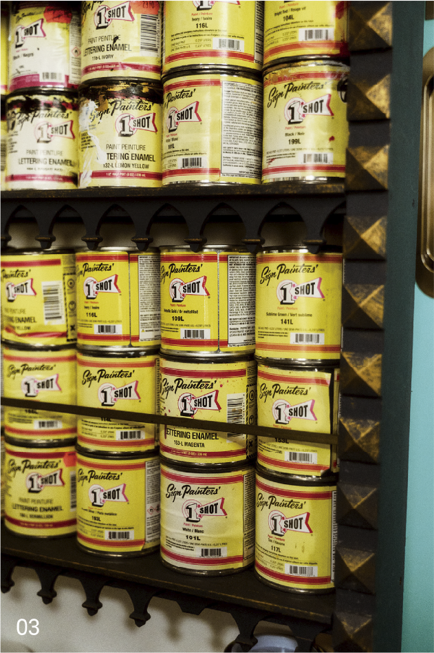 03 Una estantería llena de latas de pintura esmaltada «1 Shot».