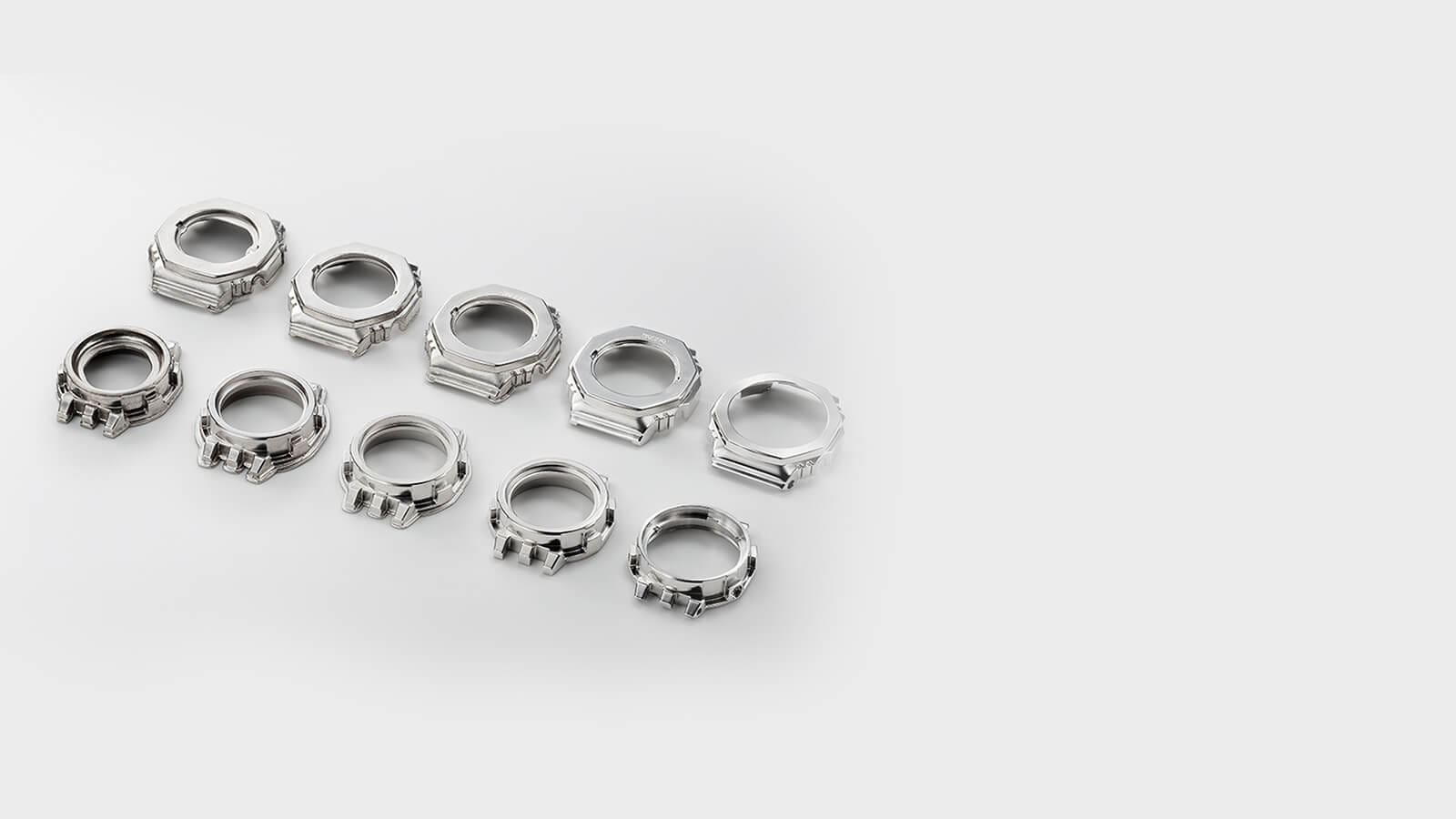   Diez biseles plateados en diferentes estados de fabricación, desde el blanco hasta el bisel terminado