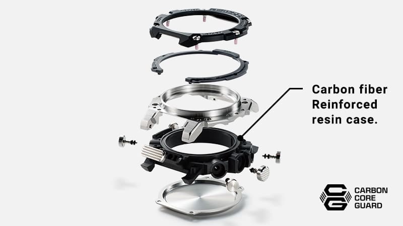 Los componentes individuales de la caja de un reloj Casio G-Steel GST-B300 dispuestos uno encima de otro, el segundo elemento desde abajo está marcado con el siguiente texto: Carbon fibre Reinforced resin case