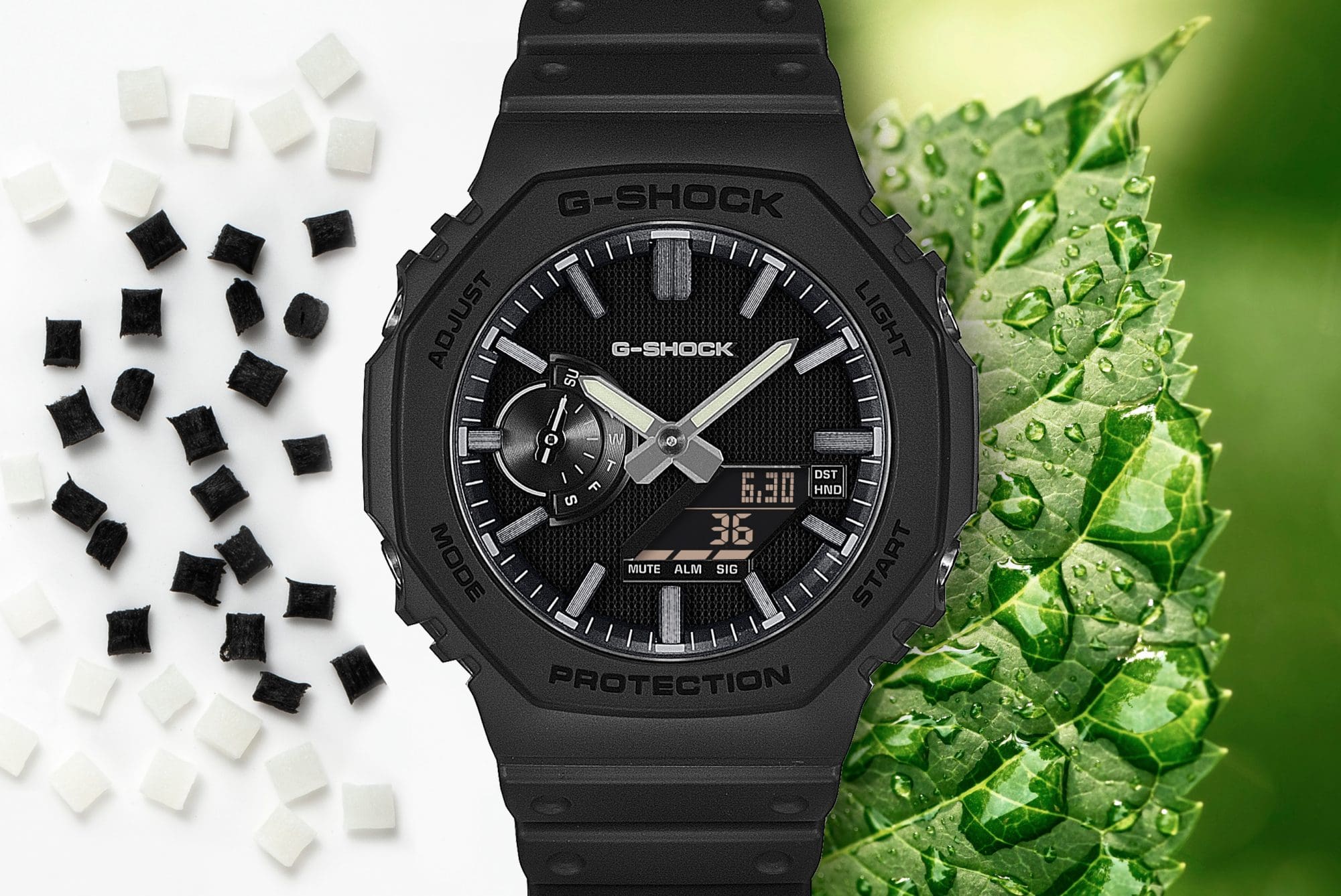 Montre G-Shock GA-2100LXB-1A noire avec boîtier octogonal, présentée sur un fond composé de cubes en résine biosourcée et de feuilles vertes, mettant en avant l'utilisation de résine biosourcée.
