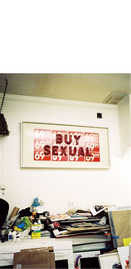 Une œuvre d'art de Steve Olson est accrochée au mur au-dessus d'un bureau encombré.