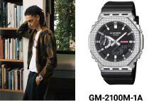 À gauche, un mannequin en tenue décontractée s’appuie sur une étagère de livres ; à droite, une photo de la montre GM-2100M-1A avec son bracelet noir et sa lunette analogique-numérique de couleur argentée. L’image possède un lien qui renvoie vers la page du produit.